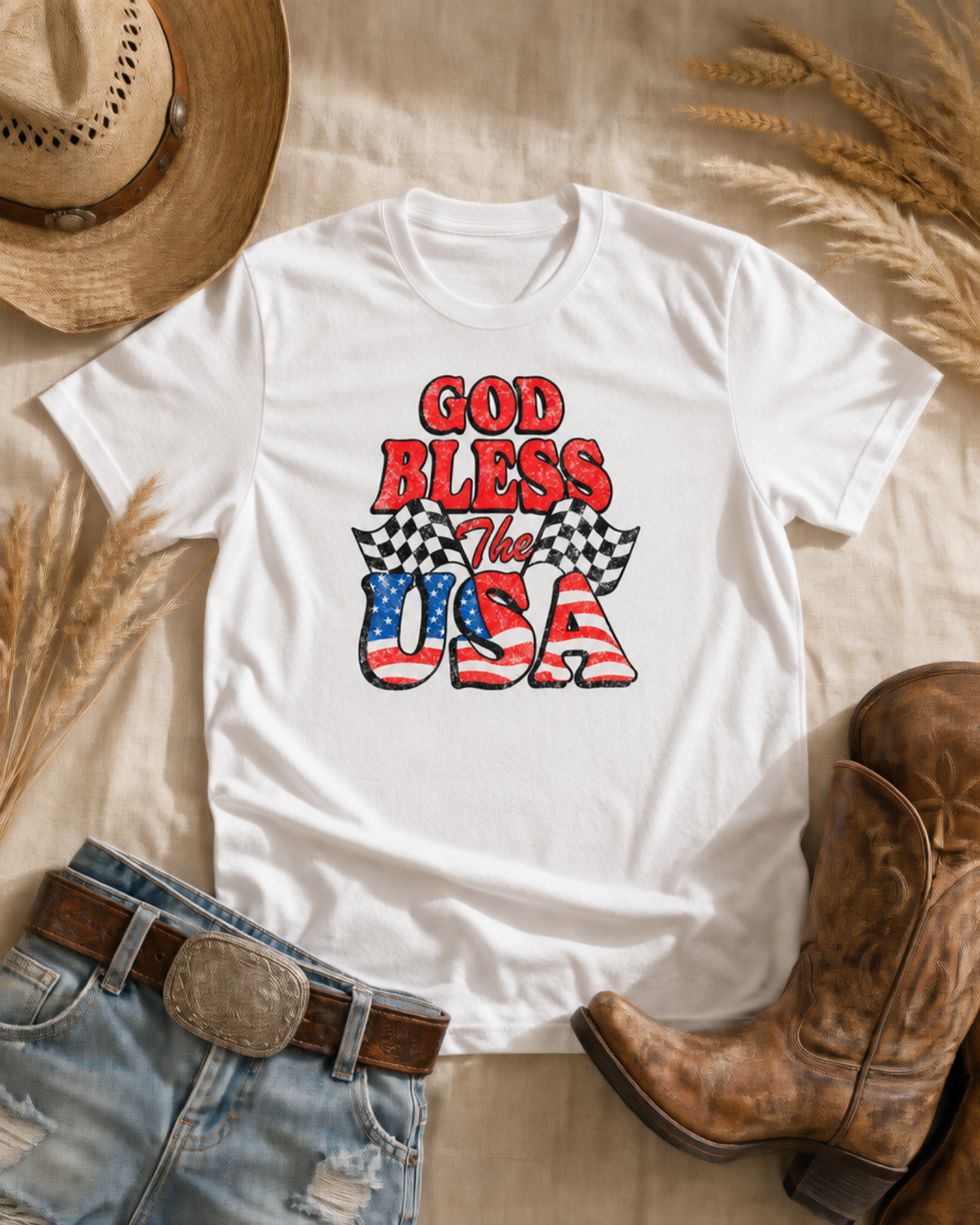 God Bless the USA T-Shirt — western flat lay with cowboy hat and boots